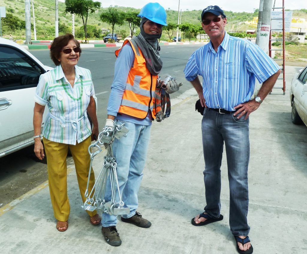Lilian de Ayala, HC4L (left), and Dr Rick Dorsch, NE8Z/HC1MD (right), and an unidentified utility lineman, whose gear intrigued Dorsch. [Courtesy of Rick Dorsch, NE8Z/HC1MD]