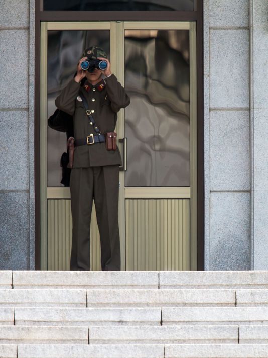 A North Korean guard uses binoculars as he stands in front of the Panmungak building in the truce village of Panmunjom in the Demilitarized Zone dividing the two Koreas. (Photo: Kim Doo-Ho/AFP via Getty Images)